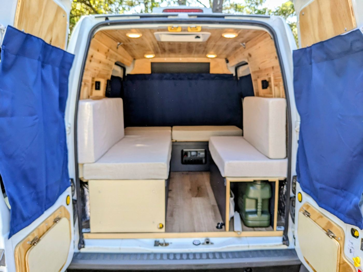  revealing a cozy wood-paneled interior in a grassy spot.|Cozy rv rental camper van interior. Wooden walls — photo 10