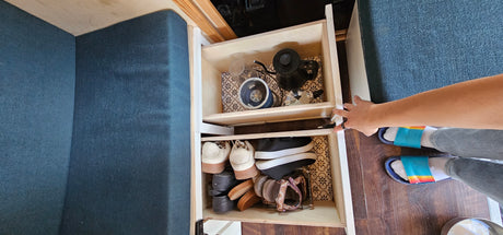RV rental: Pull-out storage drawers for kitchen essentials & shoes, maximizing space in a compact interior.