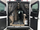 RV rental: Through open rear doors, a camper van's interior is seen with a mesh screen, compact cabinetry, and pull-out bed base.