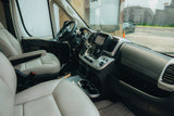 RV rental's spacious van interior: comfy driver & passenger seats, modern dashboard, and outside road view.
