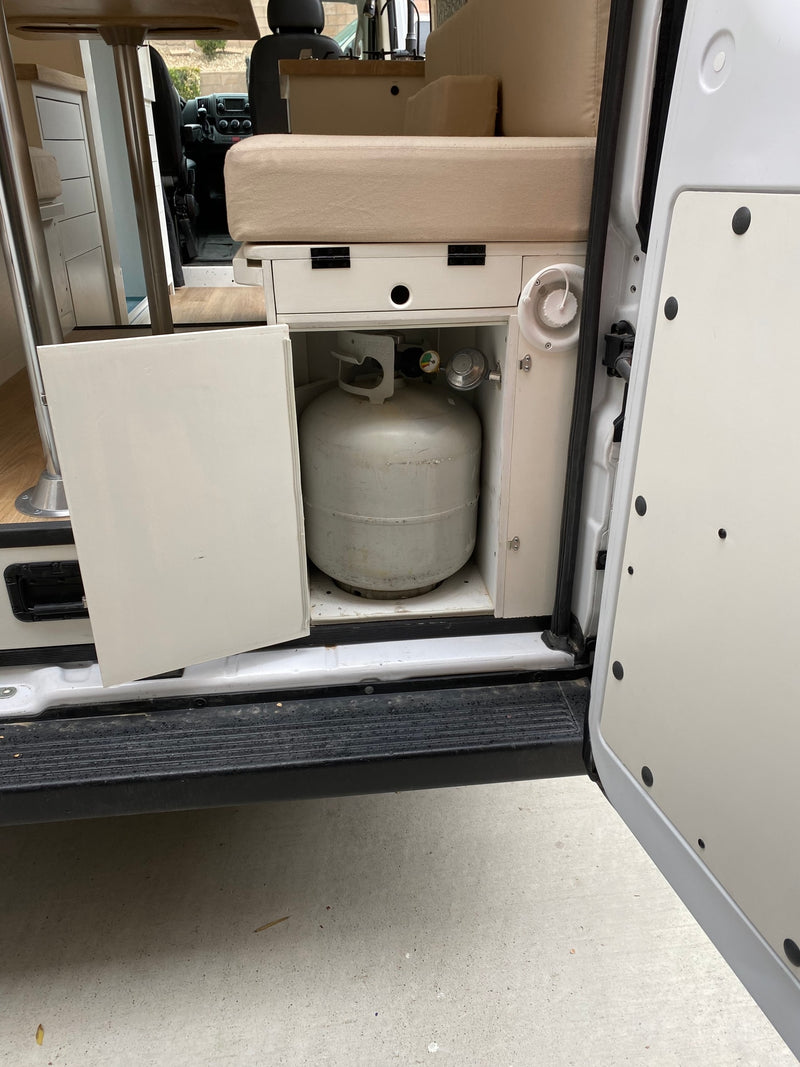 RV rental interior: open door reveals a propane tank, and part of the cozy kitchen and seating area. — photo 19