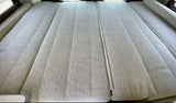 Plush, sectional bed inside an rv rental, featuring textured grey fabric for comfortable travel adventures.