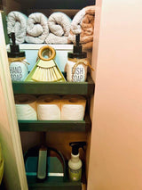 RV rental organized cabinet: Towels, hand/dish soap, TP, and cleaning supplies for a tidy trip.