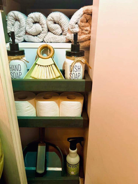 RV rental organized cabinet: Towels, hand/dish soap, TP, and cleaning supplies for a tidy trip.