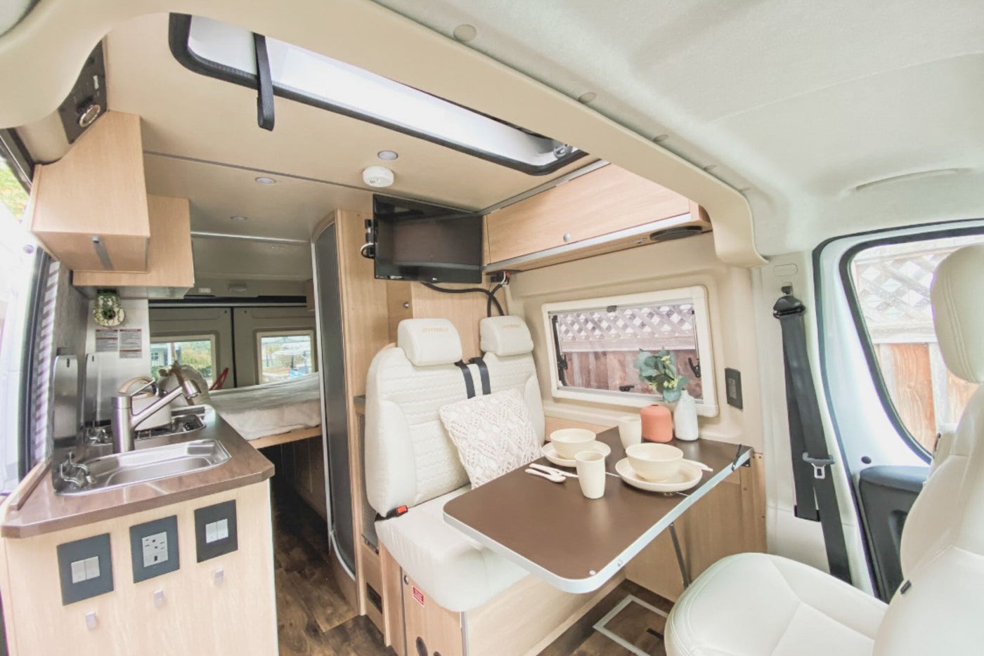  and a fire pit.|Inside an RV rental: a spacious pop-top bed with a Southwestern blanket and mesh windows overlooking a forest campsite.|Making coffee with an AeroPress and 'BUT FIRST — photo 11