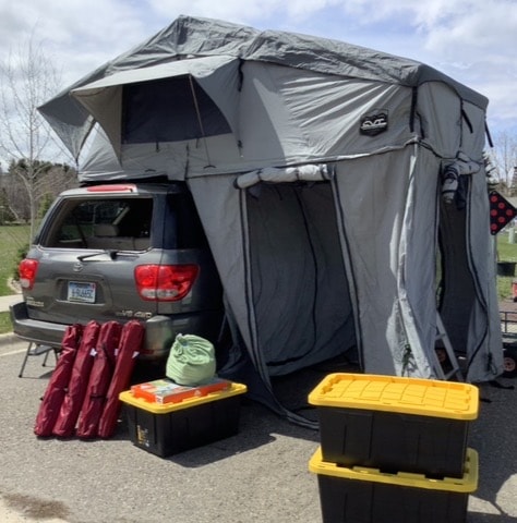  and support poles. Ready for camping adventures.|RV rental rooftop tent interior: Bright sleeping area with green mattress & overhead mesh storage. Ideal for camping.|This isn't an RV rental! It's an SUV with a full rooftop tent & annex — photo 5