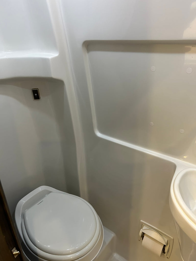 plus comfy leather seating.|Modern RV rental interior features a compact kitchen with stove — photo 12
