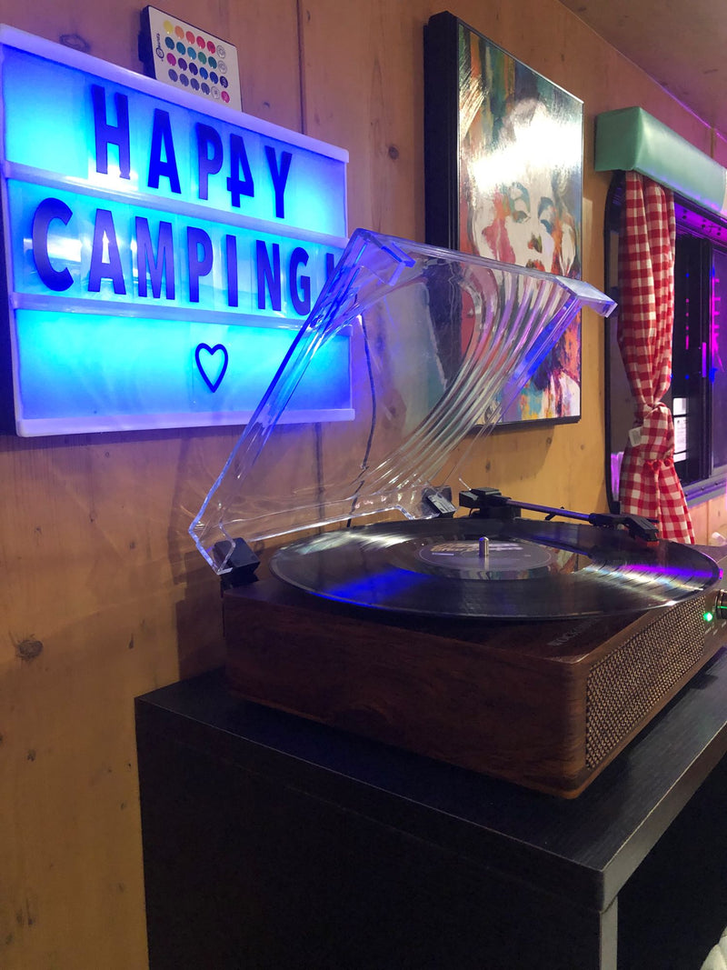 Cozy rv rental interior: 'Happy Camping' light-up sign & record player create a relaxed ambiance. — photo 7