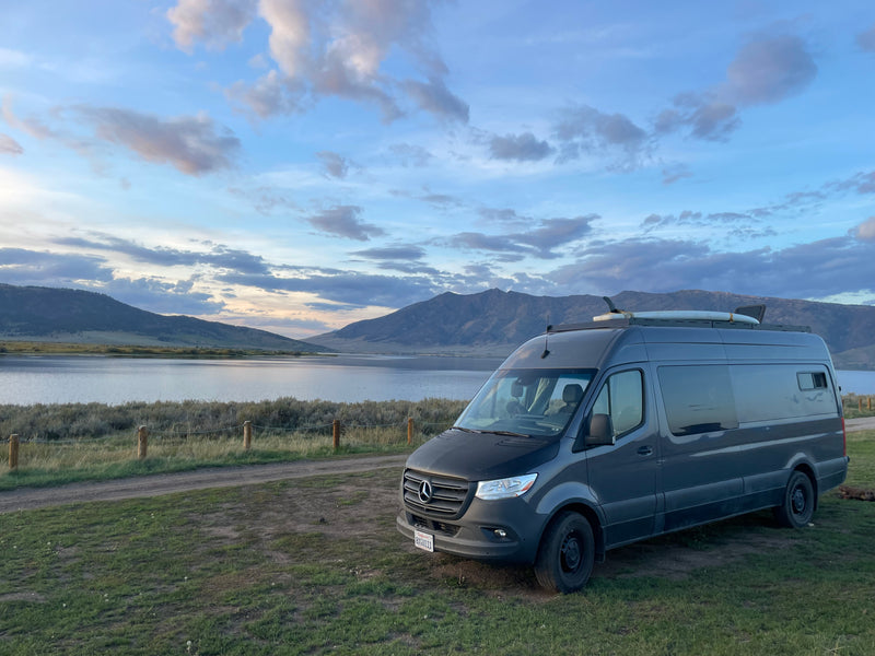 Experience van life! A grey Mercedes-Benz camper van (ideal for an rv rental) by a peaceful lake, surrounded by mountains. — photo 8