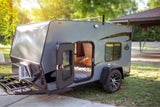 Explore this compact gray RV rental's open door to a cozy bed, perfect for your next outdoor camping adventure.