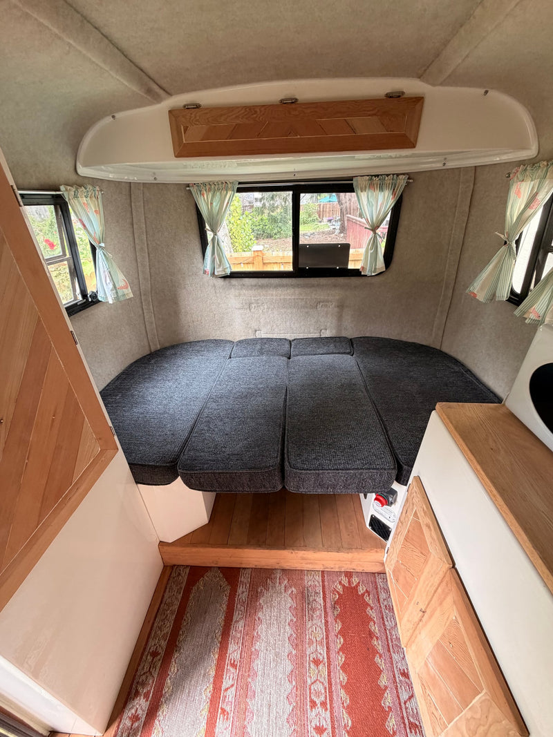 main door open to a screen door. Parked on grass with a MaxxFan on top. Ready for a trip!|Inside this rv rental — photo 9