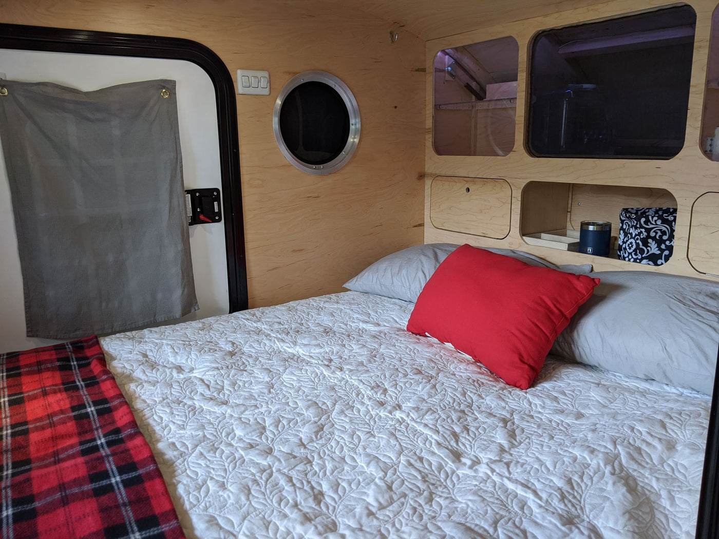 showing the decal and lower diamond plate trim.|Inside a cozy rv rental: A comfy bed with white quilt — photo 3