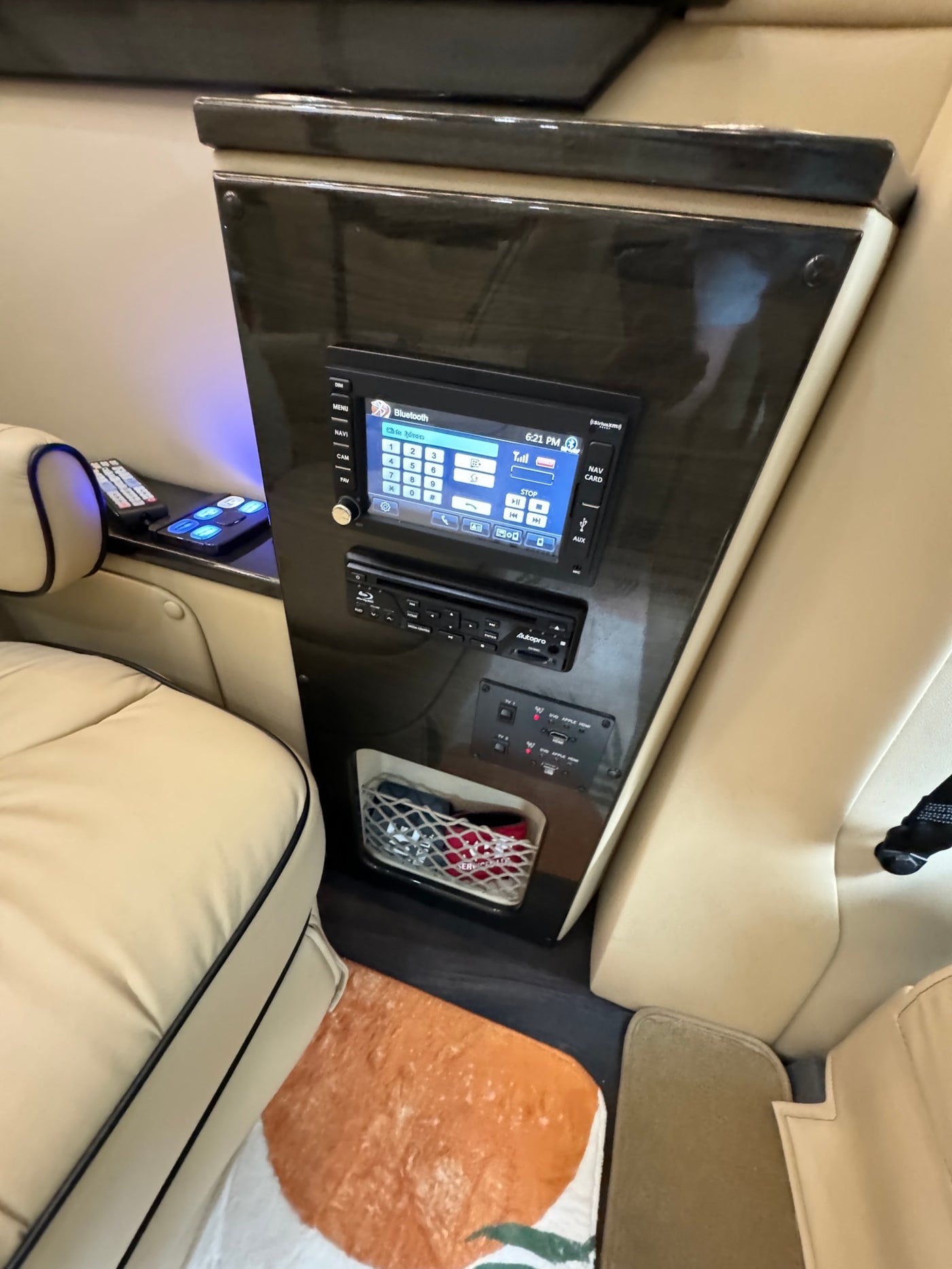RV rental interior: A sleek control panel featuring Bluetooth, a media player, HDMI inputs, and comfortable tan leather seating. — photo 10