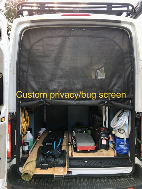 Rear view of an RV rental camper van featuring a custom privacy/bug screen & organized gear storage for adventure.