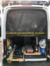 Rear view of an RV rental camper van featuring a custom privacy/bug screen & organized gear storage for adventure.