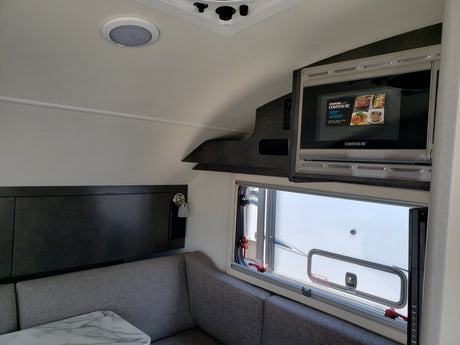 Cozy RV rental interior featuring a Contoure microwave, dinette, and bright window. Perfect for your next adventure!