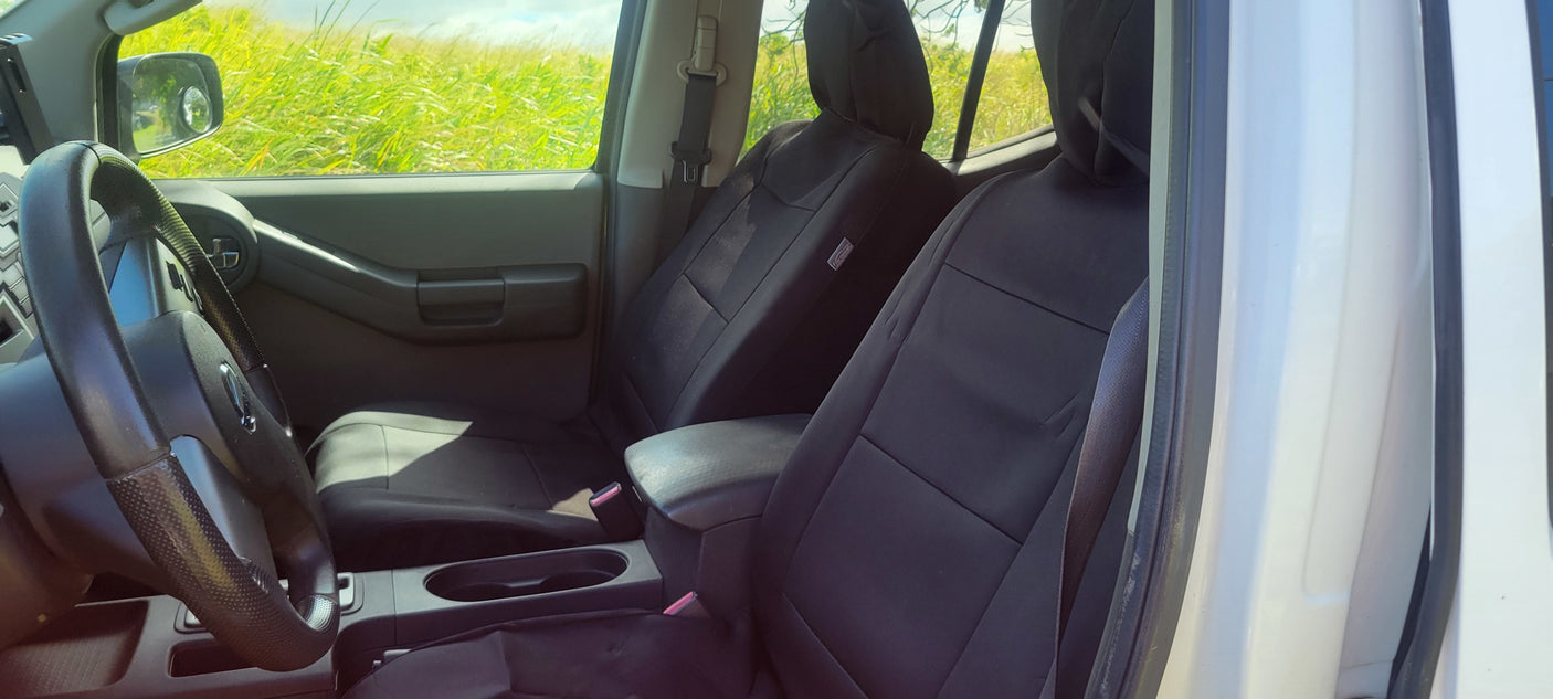 Detailed view of a spacious vehicle's interior: black seat covers, steering wheel, and console. Great for your RV rental adventure!