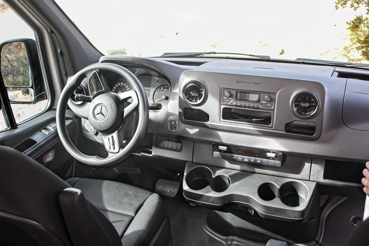 Inside a Mercedes-Benz Sprinter, a popular choice for RV rental, featuring its dashboard, steering wheel & controls.