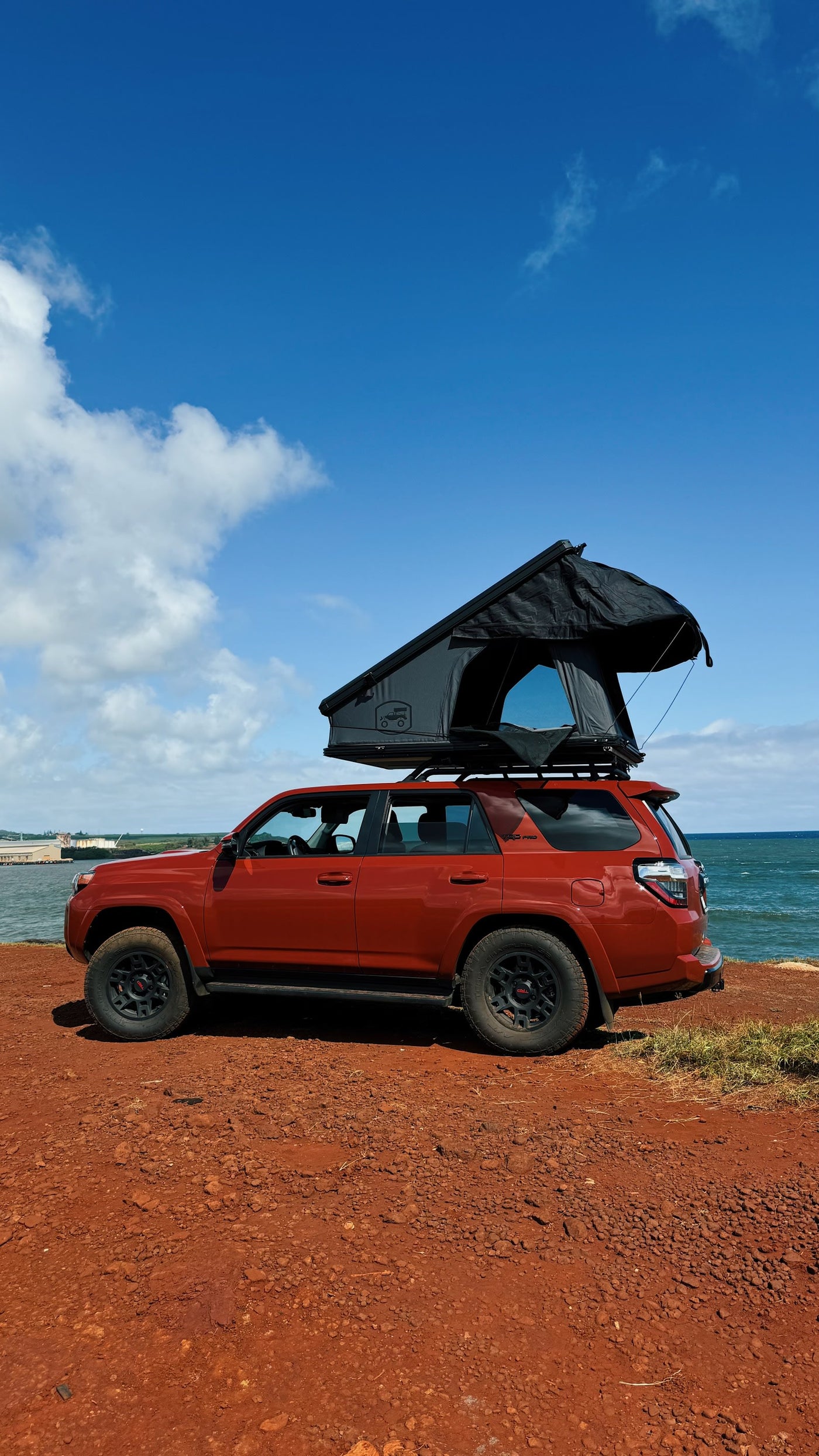 Orange 4Runner RV rental with deployed rooftop tent by the ocean, perfect for coastal overlanding adventures. — photo 12