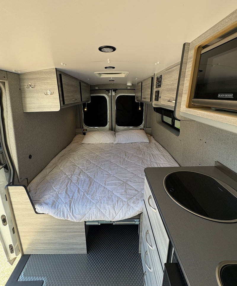 Spacious camper van interior, perfect for an RV rental adventure. Features a comfortable bed, kitchenette, and ample storage. — photo 2