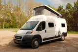 White pop-top camper van, an ideal rv rental, parked on a rustic path, ready for your next outdoor adventure.