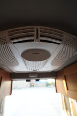 Close-up of a white Dometic air conditioning unit on an RV rental ceiling, showing adjustable vents for climate control.