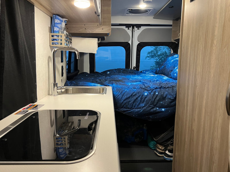  door open to the ocean view. Perfect for beach adventures!|Step inside this cozy RV rental! Features a compact kitchen with sink — photo 3