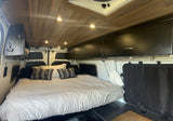 Step inside this cozy RV rental camper van, featuring a comfy bed, wooden ceiling lights, and smart storage.