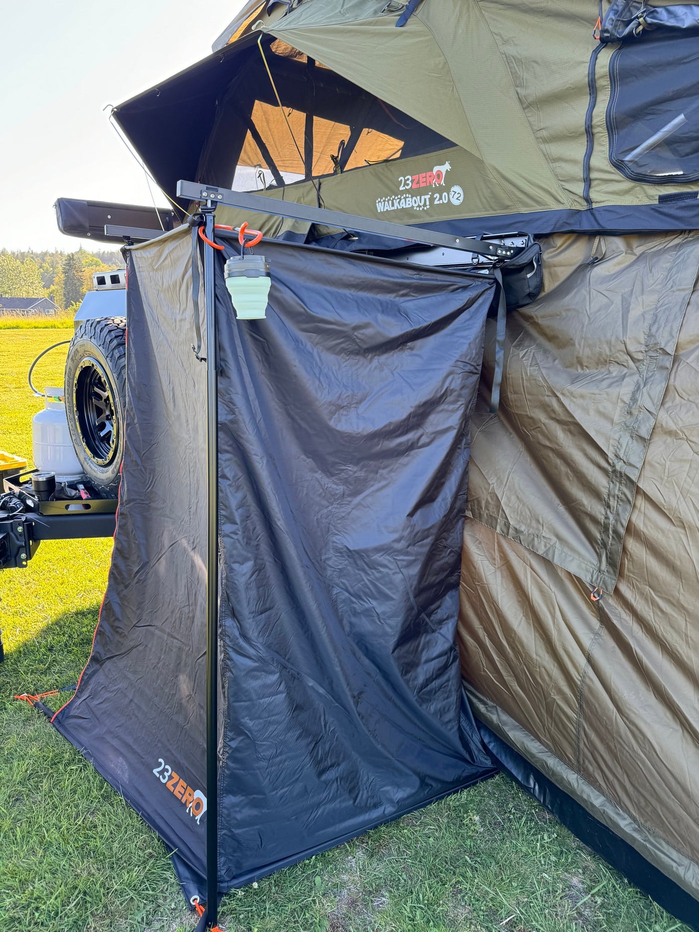 An RV rental setup: a 23ZERO Walkabout 2.0 rooftop tent with an attached privacy annex and hanging light. — photo 11