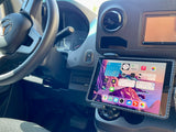 View of an RV rental van's dashboard and steering wheel, with a tablet mounted for navigation and travel apps.
