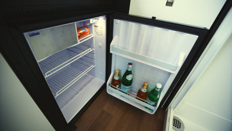 This RV rental mini-fridge with drinks like San Pellegrino and Kist soda, ready for your compact travel adventures.