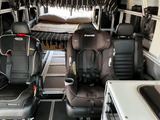 Modular RV rental interior featuring two child car seats & a bed for family adventures on the road.