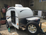 A white "Little Guy" Four Wide teardrop travel trailer, perfect for your next rv rental adventure or camping trip.