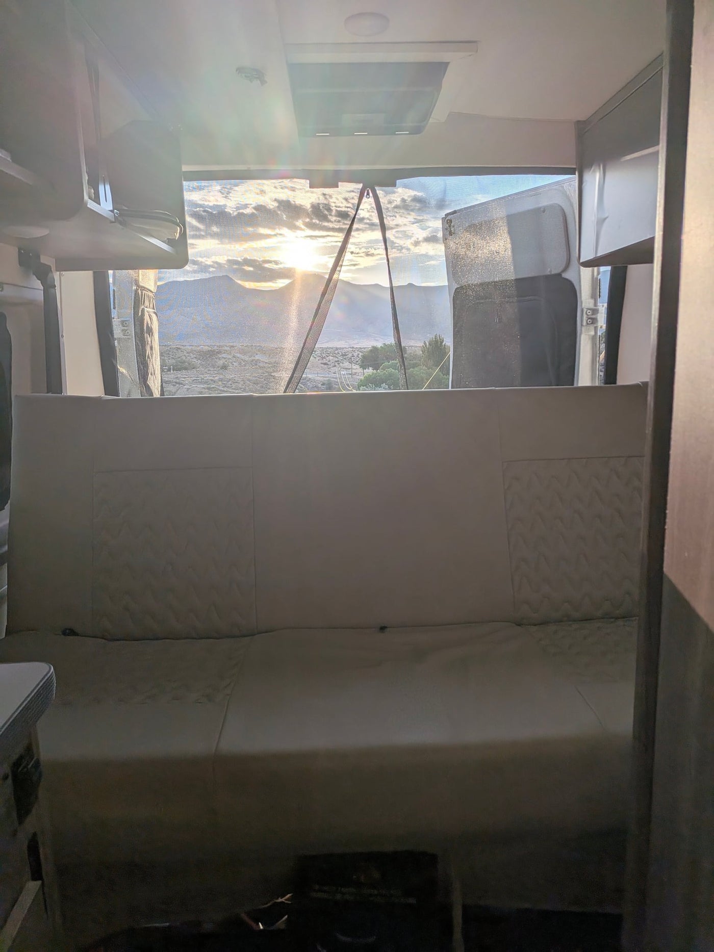  arid mountain and valley landscape.|White Winnebago Solis RV rental parked by a sparkling mountain lake with snow-capped peaks under a sunny sky.|White Winnebago Solis rv rental parked by a lake — photo 9