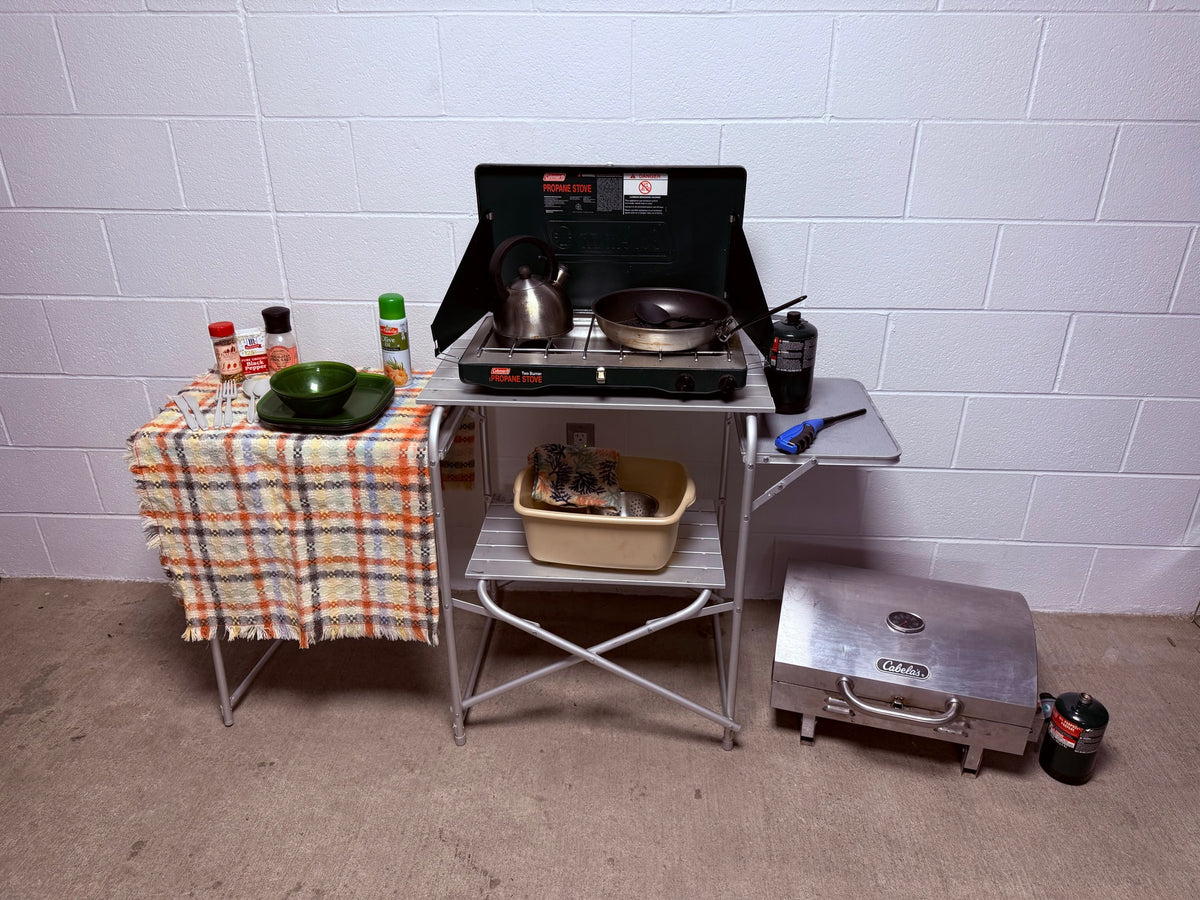 This complete portable camping kitchen, featuring a Coleman propane stove, Cabela's grill, and utensils, is ideal for any RV rental. — photo 7