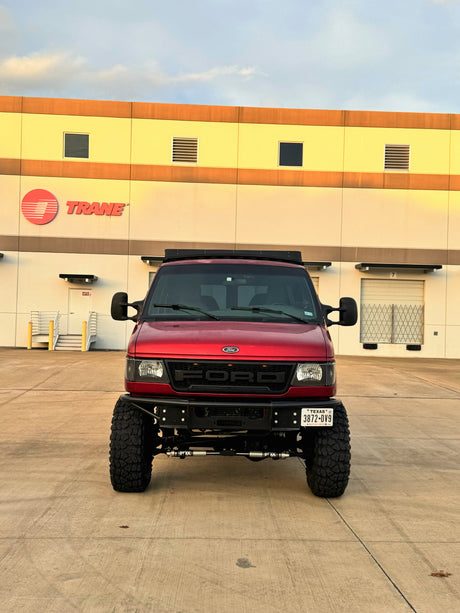 Custom red Ford adventure van, ideal for an rv rental, parked at a Trane facility in Texas.