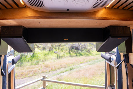 Premium Klipsch audio system with overhead soundbar/speakers in an RV rental interior, showcasing a scenic outdoor view.