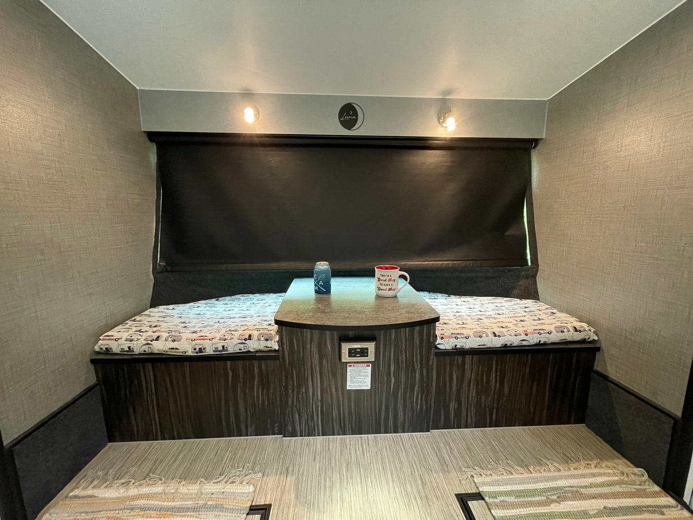 Cozy RV rental dinette: benches with camper patterns, table, and lights. Perfect for road trips!