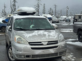 Silver minivan in a snowy lot, suggesting winter travel. RV rental and snow-covered trees highlight outdoor adventure options.