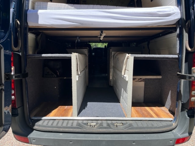  and rear seating.|Custom overhead storage in a wooden rv rental campervan — photo 15