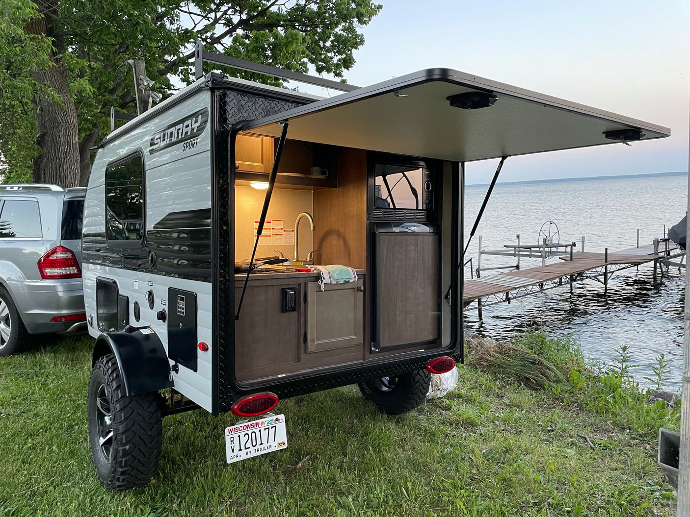 This Sunray Sport RV rental by a beautiful lake shows off its outdoor kitchen, perfect for camping adventures!