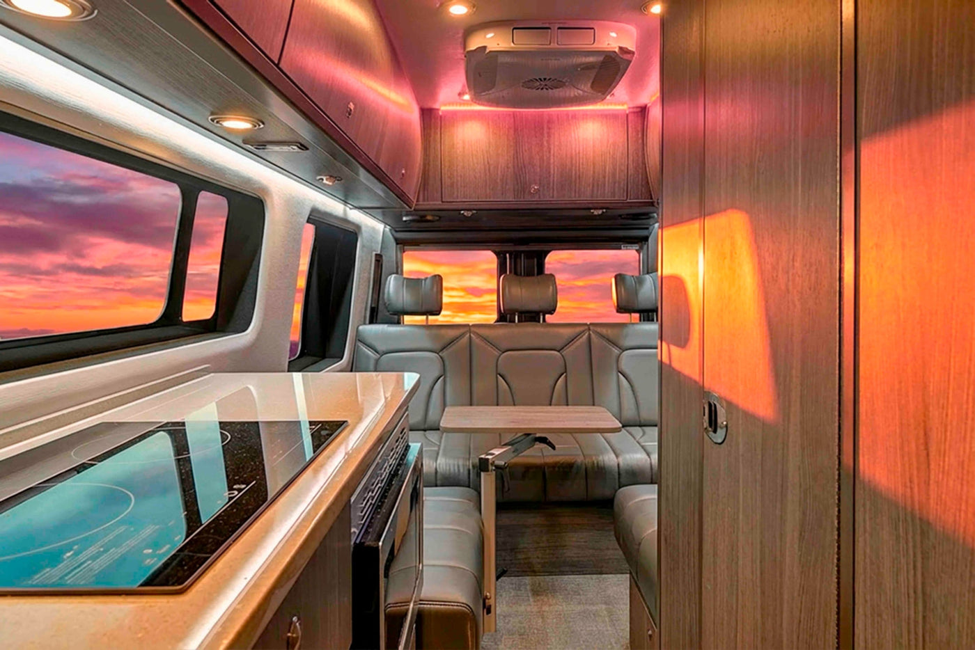  ideal for rv rental. Parked under a vibrant sunset sky.|Step inside this luxury RV rental — photo 2