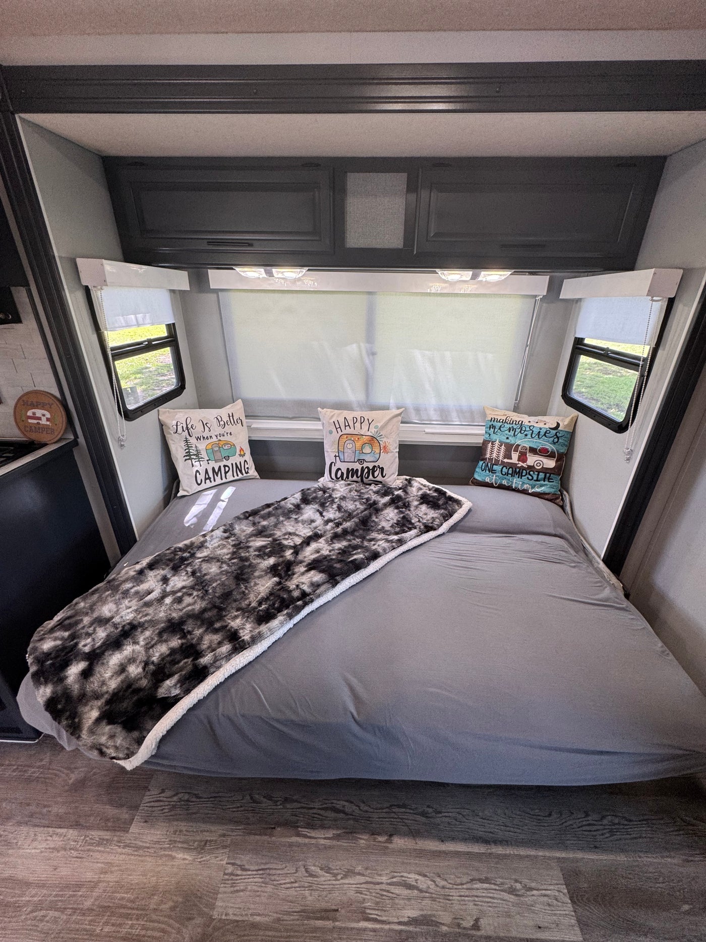 Cozy RV rental bedroom with a comfy bed, camping pillows, and windows, ideal for your next travel adventure. — photo 15
