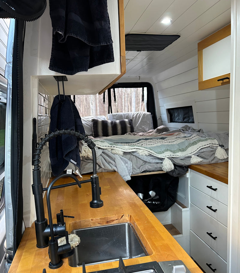 Interior of a stylish rv rental with a compact kitchen, sink, and comfortable bed. Ready for van life adventures! — photo 5