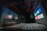 Cozy RV rental bedroom features a ceiling projector beaming entertainment onto a screen for ultimate comfort.