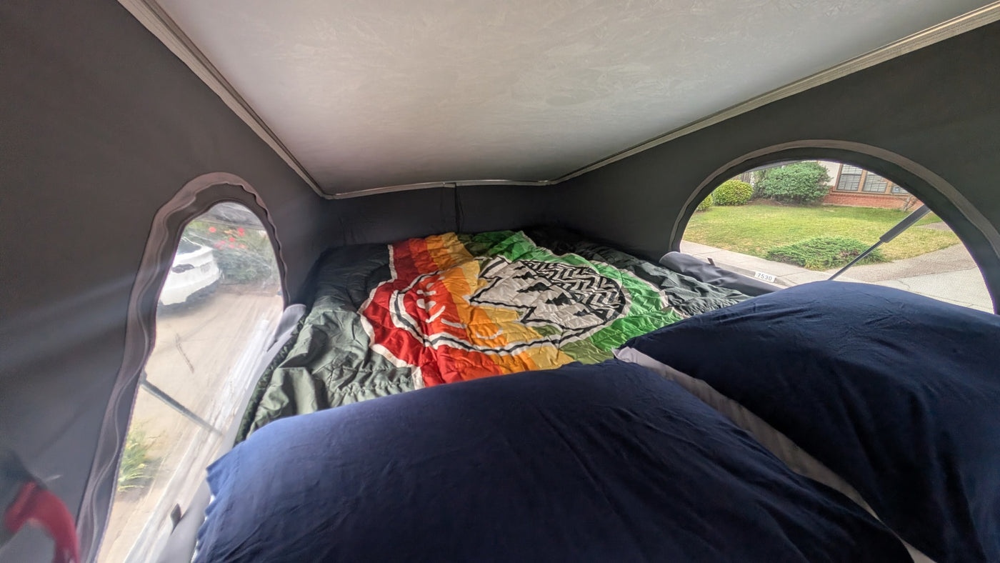  offering a panoramic view of layered desert canyons and mesas under a cloudy sky.|Interior of an RV rental camper van — photo 11