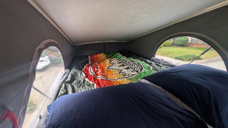  offering a panoramic view of layered desert canyons and mesas under a cloudy sky.|Interior of an RV rental camper van — photo 11