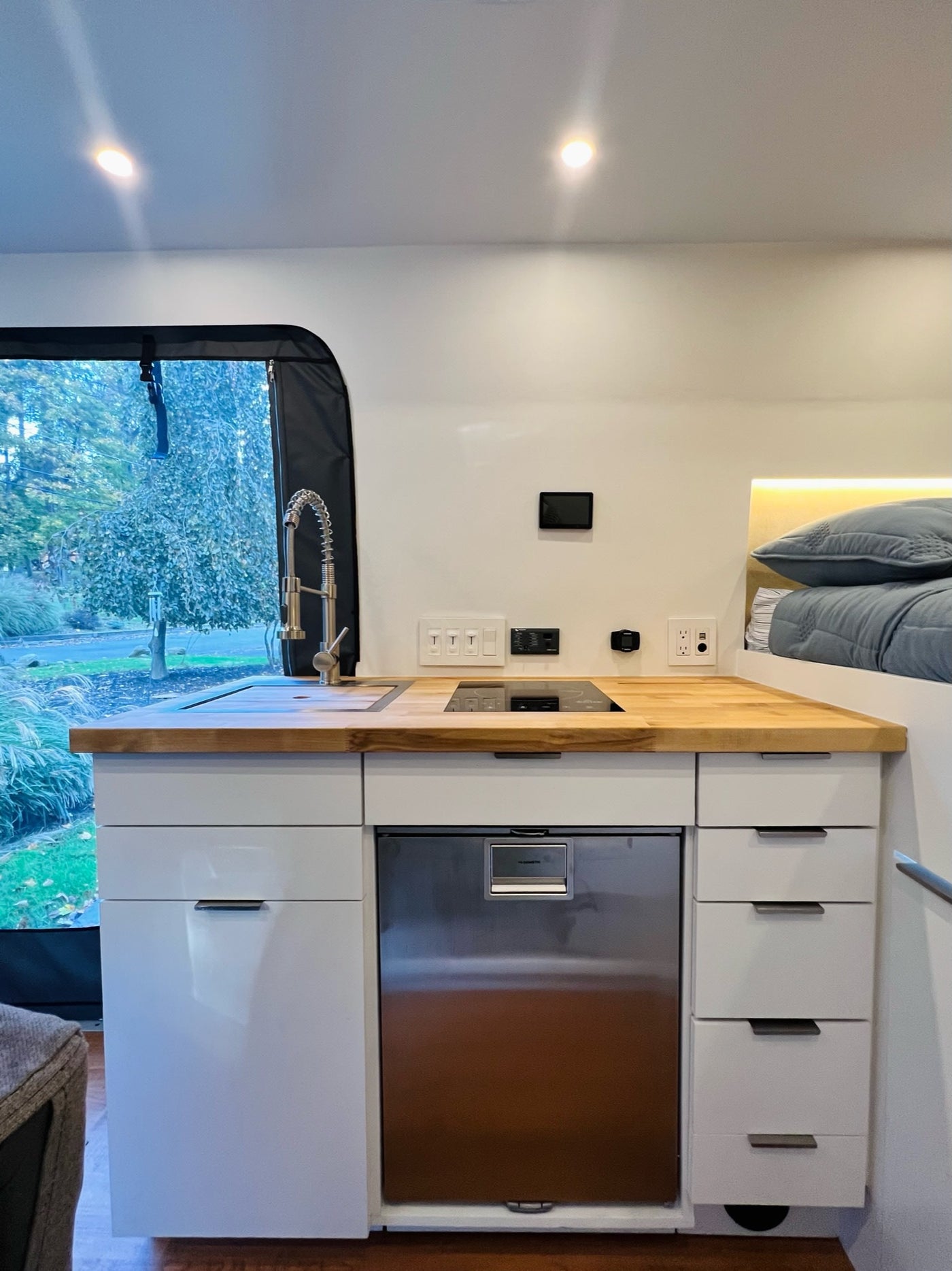  and additional sleeping area. Bright and functional design.|Dark grey RV rental camper van with open door and extended awning — photo 3