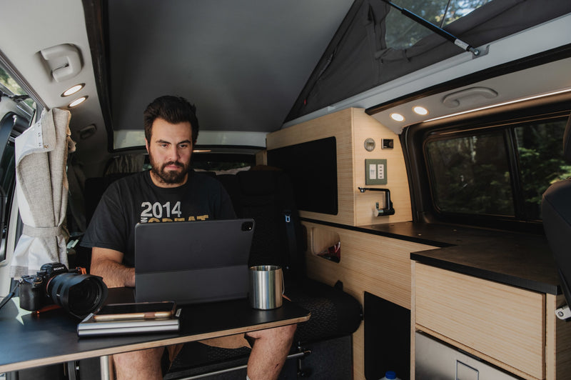  and energy monitor. Ocean view.|Exploring van life: a person in a plaid shirt opens the refrigerator in their RV rental camper van kitchenette by a lake.|Compact RV rental interior featuring a built-in wooden kitchenette with an open mini-fridge and vehicle seating.|This RV rental campervan interior offers a compact kitchen setup with a meal — photo 12