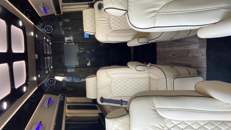  showcasing cream luxury captain's chairs and a modern entertainment system.|RV rental: New Mercedes-Benz Sprinter van interior — photo 10